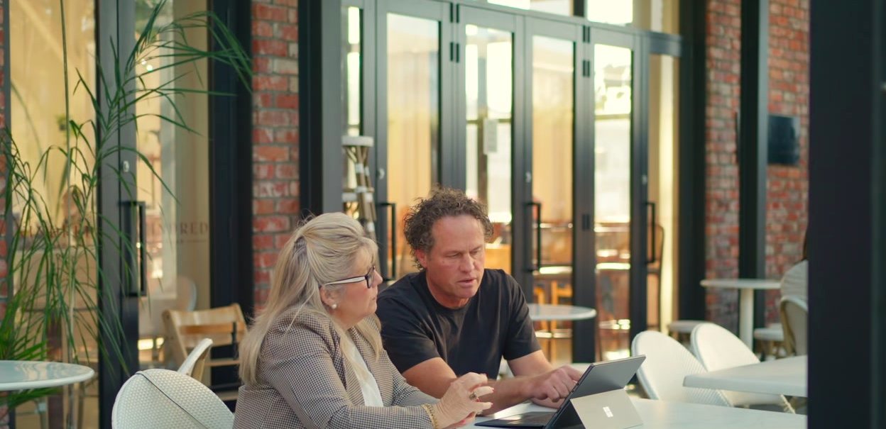 Matt and a client working through a laptop at a café table
