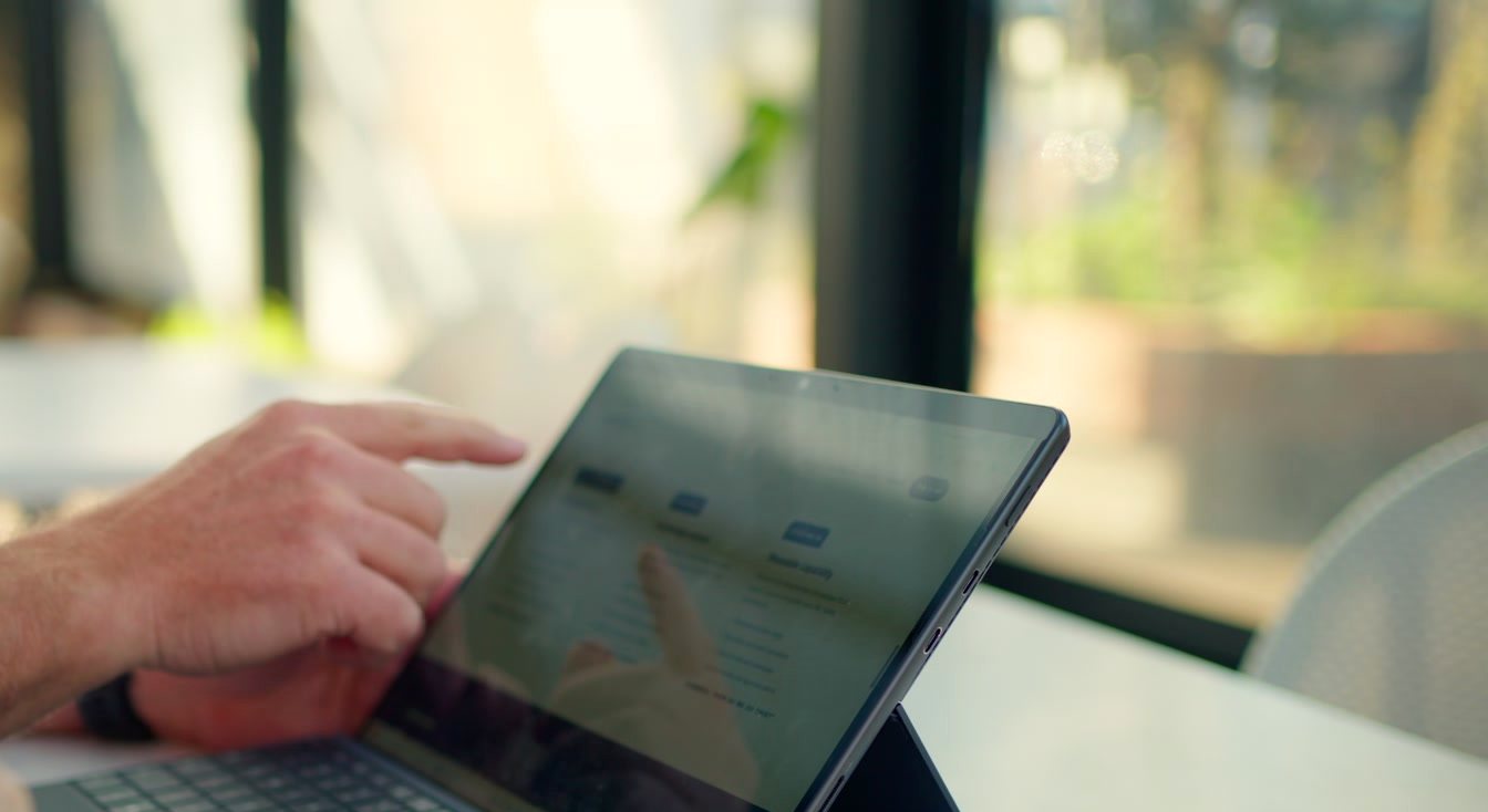 Hands on a tablet keyboard, working through a real report